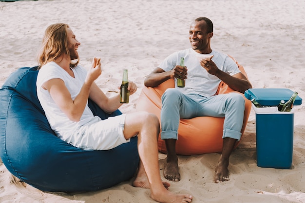 Happy Men Have Sandwiches and Beer on Shore