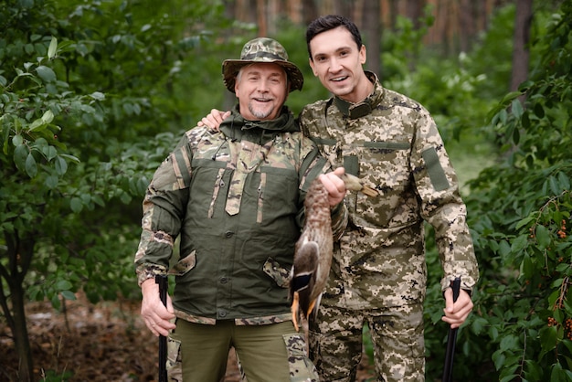 Happy Men Holding Wildfowl and Posing for Photo.