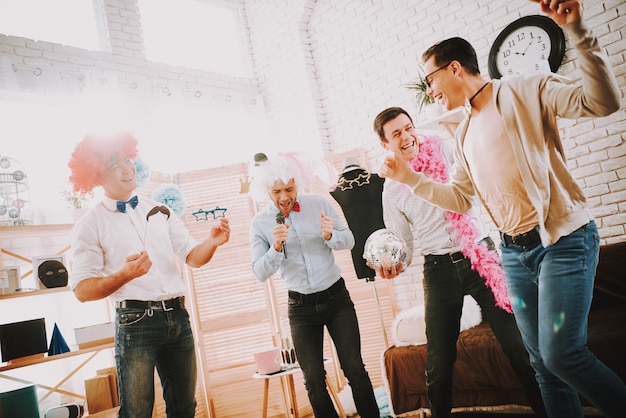 Happy men with bow ties singing karaoke songs at party.