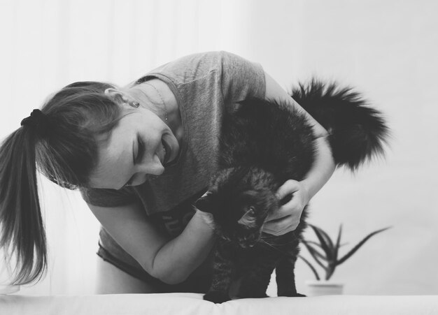 Photo happy mid adult woman playing with cat at home