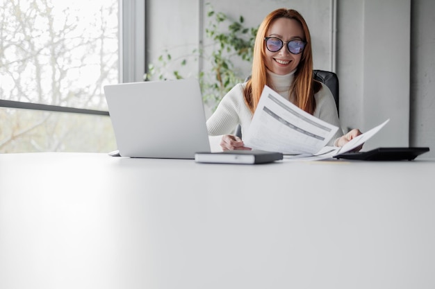 Happy mid aged business woman working with papers