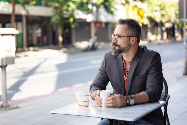 Happy middle aged businessman portrait drinking a coffee outdoors