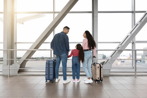 Happy middle eastern family waiting for flight together at airport