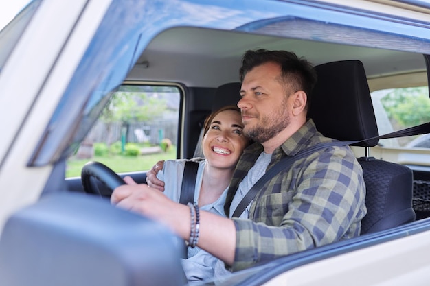 Happy middleaged couple hugging in the car