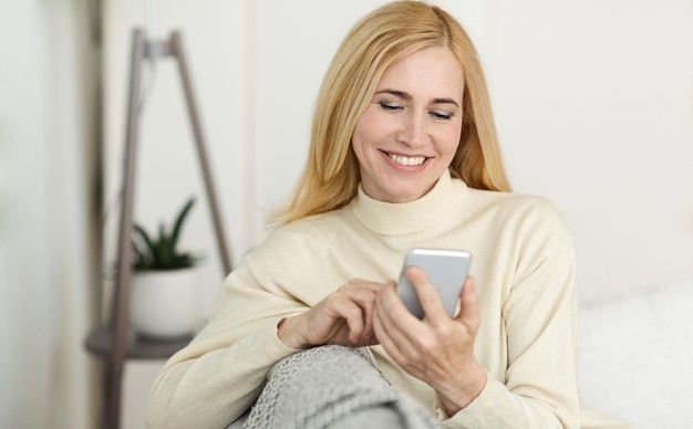 Happy MiddleAged Woman Surfing Internet On Phone