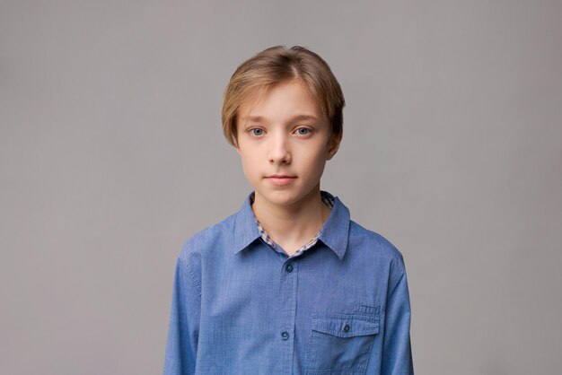 Happy millennial caucasian guy in blue shirt isolated on gray studio background smiling positive you