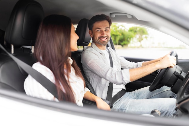 Happy millennial couple travelers have car trip together