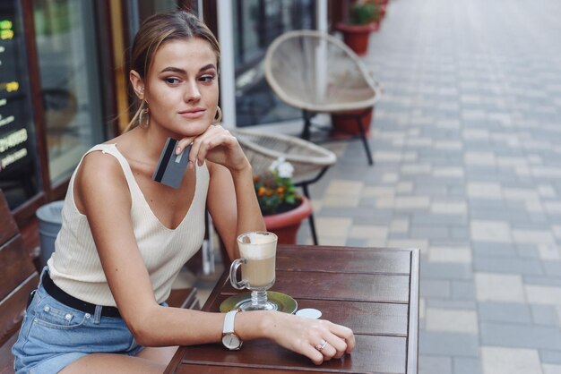 Happy millennial teen woman checking social media holding smartphone at city street