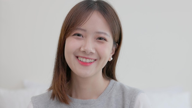 Happy millennial thai ethnicity lady student professional close up front portrait beautiful smiling confident young thai ethnic woman cute face looking at camera posing alone at home in homexA