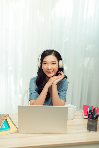 Happy millennial woman enjoying studying remotely at home.