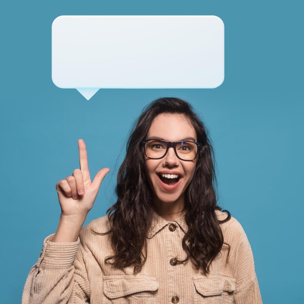 Happy millennial woman in glasses showing empty white speech balloon