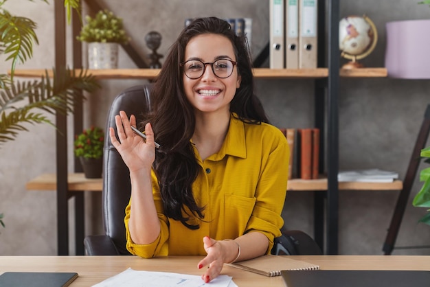 Happy millennial woman wave talk on webcam or having conversation for job video call