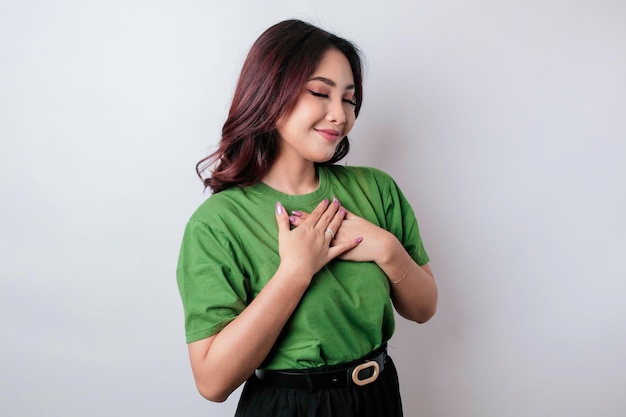 Happy mindful thankful young woman hand on chest smiling isolated on white background