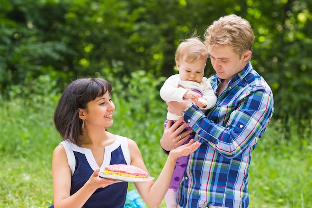 Happy Mixed Race Family Having a Picnic and Playing In The Park.