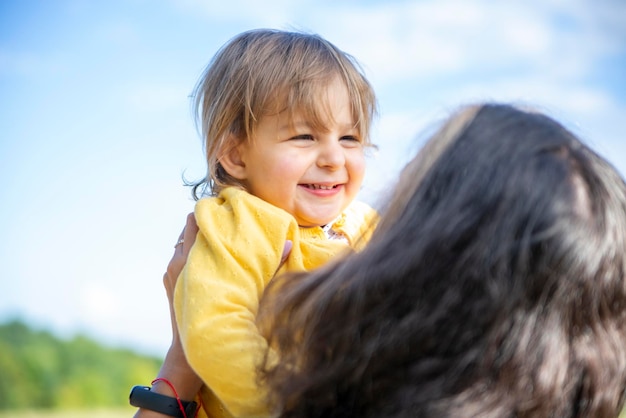 Happy mom and baby play in the field in summer on a sunny summer day