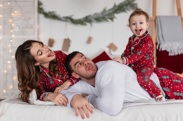 Happy mom dad and daughter The morning before christmas