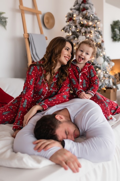 Happy mom dad and daughter The morning before christmas