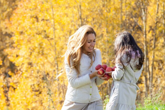 Happy mom and daughter in autumn park