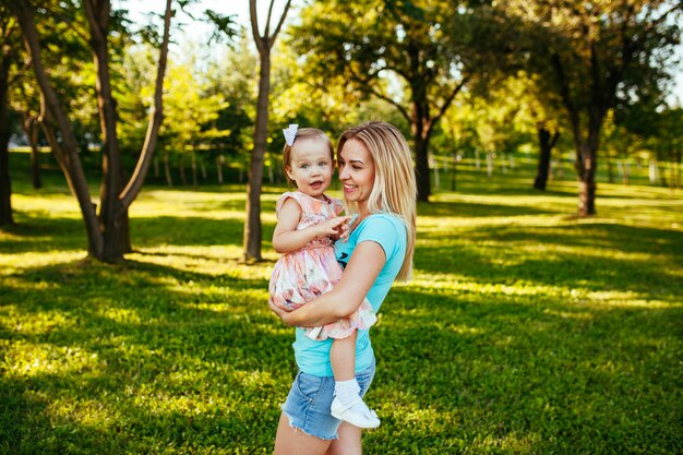 Happy mom and daughter smiling at nature.