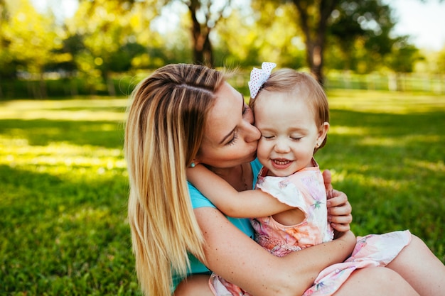 Happy mom and daughter smiling at nature.