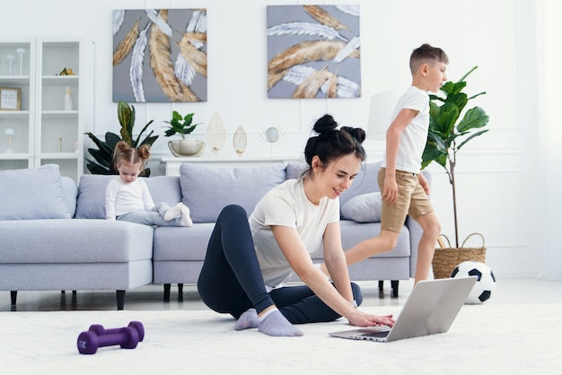 Happy mom on the floor at home with laptop