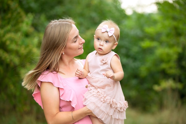 Happy mom holds a cute daughter in her arms