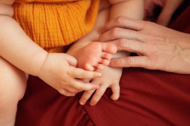 Happy Mom holds the pen of a small child in her arms close-up.