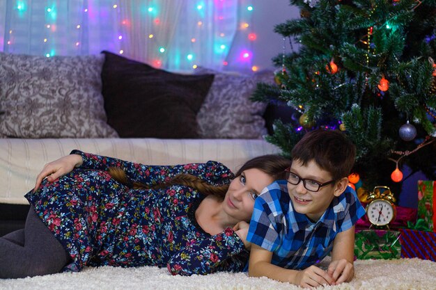 Счастливая мама и сын дома празднуют Рождество Новогоднее настроение Новогодняя елка и подарки