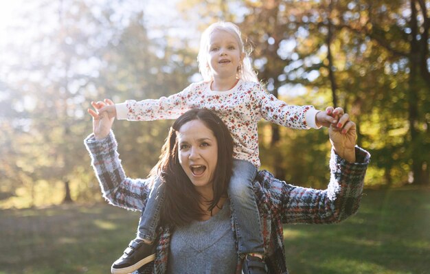 Mamma felice con la piccola figlia nella ricreazione all'aperto del parco di autunno mamma e figlia