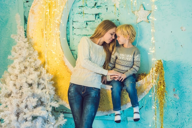 Photo happy mother and adorable boy celebrate christmas. new year's holidays