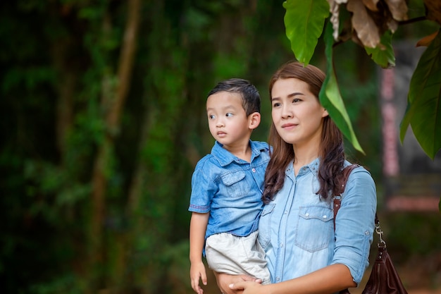 Photo happy mother and adorable little boy enjoying warm weather at beautiful park