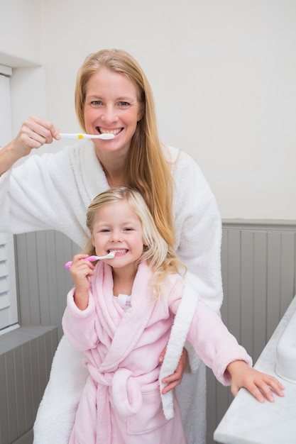 Фото Счастливая мать и дочь чистят зубы