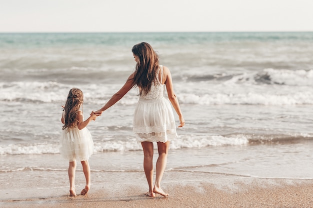 Daughter back. Обычная женщина с дочкой на пляже. Фото на море девушки с дочкой.