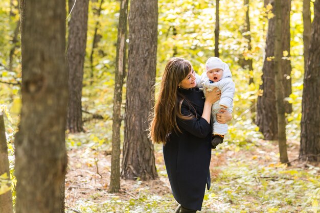 Happy mother and baby outdoor in the autumn park.