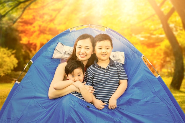 Happy mother camping with their sons at autumn