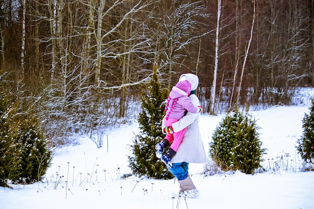 Happy mother and daughter having fun Family playing at winter park