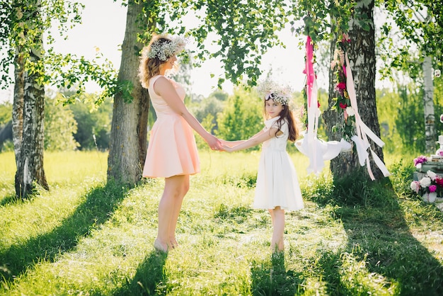 Happy mother and daughter holding hands in the summer