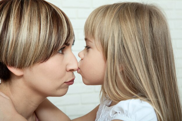 Happy mother and daughter kissing