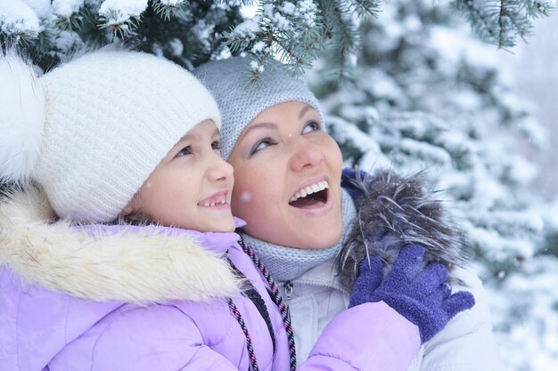 Happy mother and daughter, posing outdoors in winter