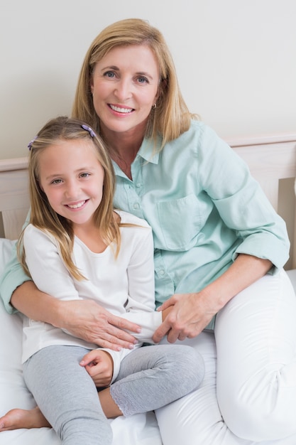 Happy mother and daughter smiling at camera 