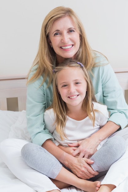 Happy mother and daughter smiling at camera 