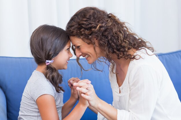 Happy mother and daughter smiling at each other