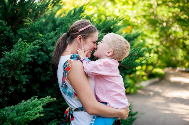 Photo happy mother and daughter standing against trees