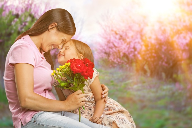 Happy Mother and daughter together with flowers