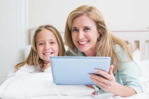 Happy mother and daughter using tablet 