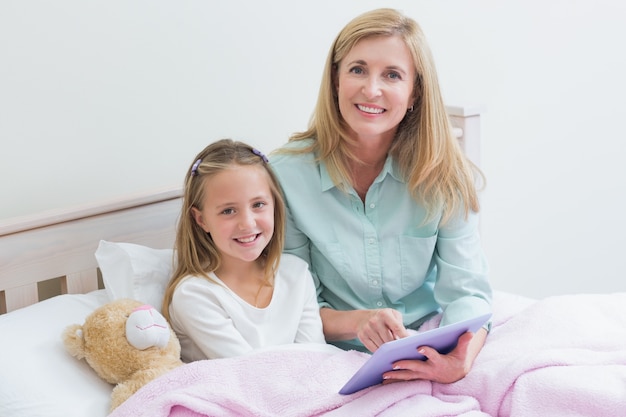 Happy mother and daughter using tablet 