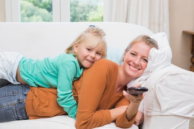 Happy mother and daughter watching tv