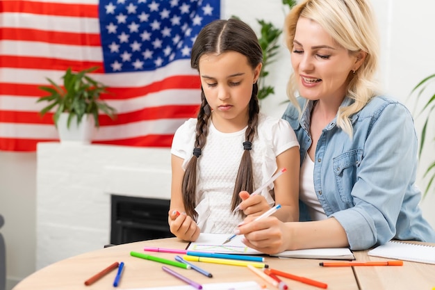 happy mother and daughter with american flag at home.