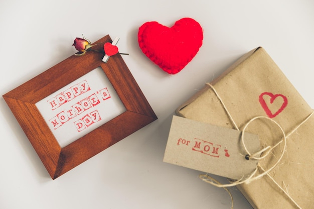 Felice festa della mamma testo in cornice di legno con confezione regalo artigianale su sfondo bianco