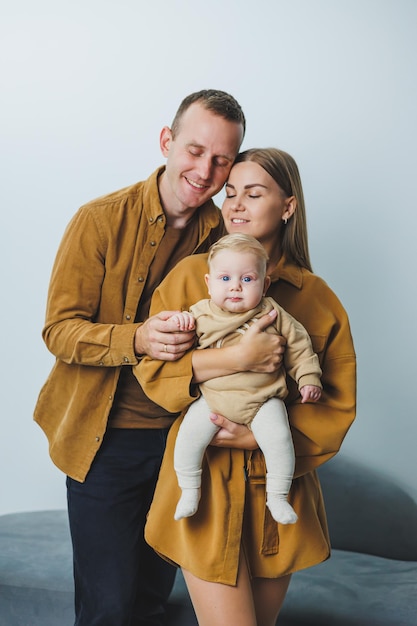 幸せな母と父が4ヶ月の息子を抱きしめている 新生児を抱いた幸せな両親の家族写真 家族コンセプト
